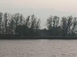 Doorkijk vanuit Wilsum naar het Erve Scholpenoirt in de Onderdijkse Waard. Deze hoeve was dicht bij de veeroever aan de Onderdijkse kant gelegen