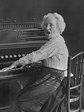 Esther de Boer-van Rijk in de rol van Eva Bonheur zingt een psalm aan het harmonium (tussen 1917 en 1937).