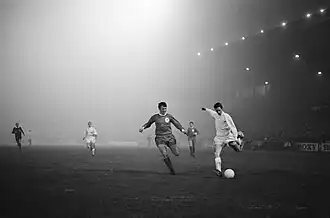 Cruijff zichtbaar in de mist, met Tommy Smith naast hem