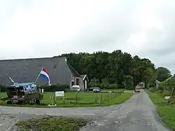 Ingang naar het fruitbedrijf met rechts de boomgaard.