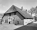 Boerderij met rieten wolfdak en voorgevel met jaartalankers: 1837 en vensters met luiken en kleine roedenverdeling