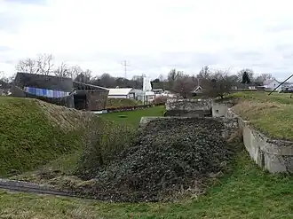 Zicht over de opstelplaatsen en munitiemagazijnen naar het nieuwe paviljoen