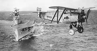 Een Flycatcher vliegt over HMS Eagle in 1930