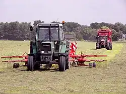Dubbele hark (met daarachter een trekker met opraapwagen