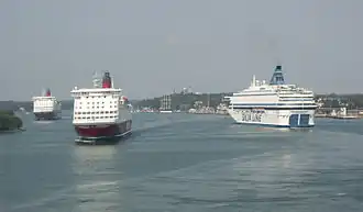 Grote veerschepen varen af en aan.