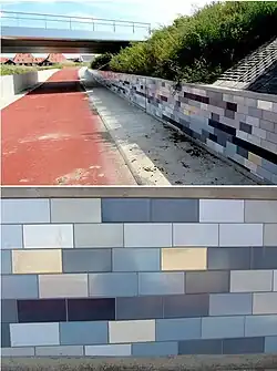 Op de betonnen randen van de fietstegel zijn tegeltableaus aangebracht. Voor de kleurstellingen liet de kunstenaar zich inspireren door de weerspiegeling van het nabij gelegen water van het Alddjip. De tegels zijn gemaakt door Tichelaar, Makkum.