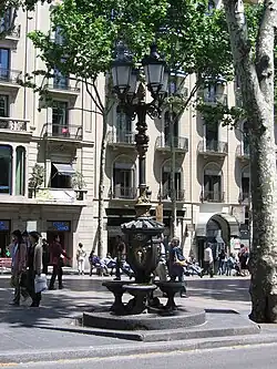 Font de Canaletes, een 19e-eeuwse, gietijzeren fontein met straatlantaarn in het noordelijk deel van de straat, bij Plaça de Catalunya