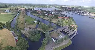 Het T-vormige gemaal en het boezemkanaal liggen links van het dorp en het Spaarne. Nog verder westelijk ligt als "eiland" het Fort bezuiden Spaarndam.