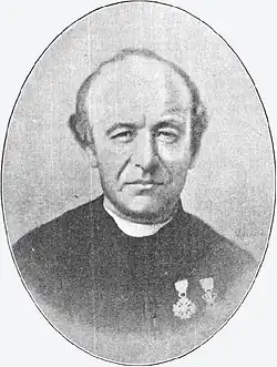 Zwart-witfoto (104 × 63&nbsp;mm) van Guido Gezelle uit 1889 door de Kortrijkse fotograaf Gustave Macaire. Het werd door het atelier Société Belge des Portraits Bogaerts te Brussel gebruikt als basis voor de vervaardiging van een olieverfportret.