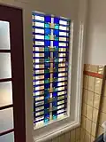 Fraai glas-in-lood-motief naast de deuren aan de achterzijde.