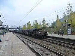 Een goederentrein richting Zweden, op de achtergrond de brug van de Kongelundsvej bij het oosteinde van de perrons.