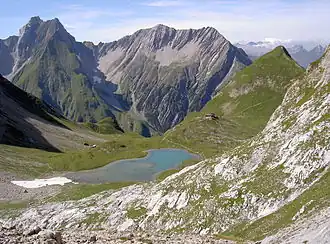 De Freispitze (links) en de Saxerspitze (2690 meter). Op de voorgrond de Memminger Hütte met zijn huisberg, de Seekogel (2412 meter) en de Unterer Seewisee, vanuit het oosten