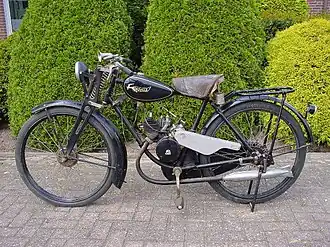 Gazelle uit 1935: de fiets is herkenbaar. De trappers drijven een ketting rechts aan, met kettingkast; de motor heeft een eigen ketting aan de linkerkant.