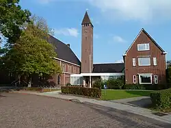 Gereformeerde kerk uit 1938 (nu PKN) met rechts de pastorie