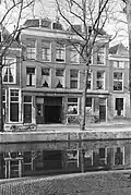 Woonhuis, samen met het vrijwel identieke rechter buurpand rond 1870 gebouwd in sobere traditioneel-classicistische vormen. Rechts op het achterterrein een voormalig bedrijfspand uit de 17de eeuw of eerder, mogelijk in oorsprong een brouwerij, waarbij het kan gaan om ¿De Pauw¿.
