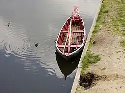 De mast met het zeil ligt in de boot.