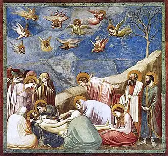Giotto's Lamentation of Christ (1300s) fresco at the Cappella degli Scrovegni (Padova) has figures with their backs to the scene.