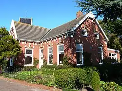Schoolmeesterswoning (1906). Bevat gevelsteen van gesloopte gereformeerde school (foto).