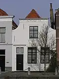 Sint Christoffel. Huis met gepleisterde ingezwenkte gevel, lijst met klosjes. Staafankers. Voordeuromlijsting