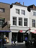 Pand met gepleisterde ingezwenkte lijstgevel. Winkelpui