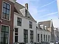 Kantoorgedeelte met gepleisterde lijstgevel aan de straatzijde en uitgebouwd gedeelte aan de tuinzijde