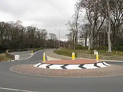 De rotonde bij Governor's Bridge. De coureurs gebruiken de hoofdweg niet, maar komen uit het parallelweggetje en draaien scherp rechts via "Governor's Dip". De witte stenen kolom heeft altijd in de bocht gestaan, maar het origineel werd in de jaren nul door een vrachtwagenchauffeur omver gereden. Enkele jaren lang werd de weg door strobalen gemarkeerd, maar omdat de kolom "historische waarde" voor de TT had werd een replica geplaatst
