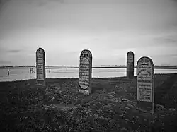 Enkele grafstenen op de zeedijk met uitzicht op de Dollard.