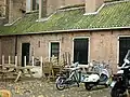 Laag pakhuisje gelegen tegen de noordoostzijde der St.Joriskerk. Voormalige Diakoniewoning