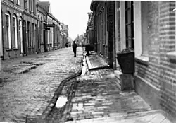 Het oostelijke deel van de Barestraat rond 1927 gezien vanaf het oosten naar het westen met op de achtergrond een excentrisch geplaatst gebouw, dat later werd verwijderd om de straat te verbreden.