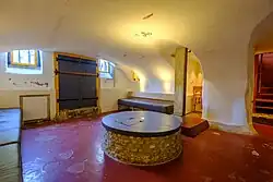 De kelder van pakhuis De Sleutel in Groningen met in het midden een waterput en erboven de 17e-eeuwse aanduiding IHS, die naar de katholieke geschiedenis verwijst.