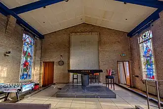 Het altaar in de kapel met gebrandschilderde glazen aan weerszijden (2023)