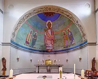 Apsis met motieven in vroegchristelijke stijl van Lambert Simon. In het midden Christus als Salvator Mundi (heilbrenger) met vier heilsgetuigen: Mozes en Elia(s) uit het Oude Testament en Simon en Johannes uit het Nieuwe Testament.
