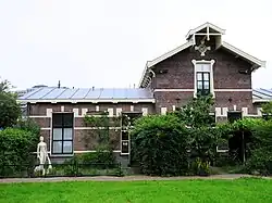 Het badhuis in 2024, links het beeld Vrouw met twee dolfijnen