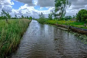 De Grootegastertocht naar het zuiden gezien vanaf de Westerzand/Abel Tasmanweg. Links de Sebaldebuurstermolenpolder en rechts de Grootegastermolenpolder. Het water vormt ook de scheiding tussen de dorpsgebieden van Lutjegast en Sebaldeburen.