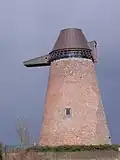 De gevels en daken van de windmolen "Les Golettes" te Velaine, ensemble van de molen en de omgeving