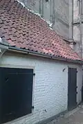 Gepleisterd pandje zonder verdieping, onder lessenaarsdak tegen de mariakerk