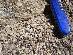 Grus, hoekig, veldspaatrijk zand, en het granietgesteente (linksboven) waaruit het ontstaat