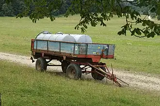 Oranje autonome aanhangwagen geparkeerd achter een kerk
