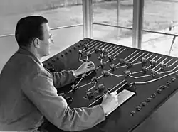 Seinhuiswachter bij het heuveltoestel in het seinhuis Post II van het rangeerterrein Watergraafsmeer; circa 1949.