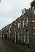 Koetshuis en stallen van het er achter gelegen erf aan de Nieuwe Gracht, houtversierde middenpartij, grote staldeuren