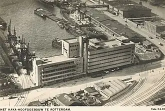 Luchtopname van het HAKA-gebouw van de Coöperatieve Groothandelsvereeniging De Handelskamer, aan de Vierhavensstraat, uit het oosten. Op de achtergrond de Lekhaven.