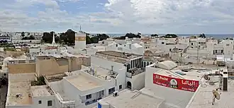 De Medina (oude stad) van Hammamet, met links de vierkante minaret van de Grote Moskee en daarachter (met het geboomte en het witte, raket-achtige monument) de Place des Martyrs