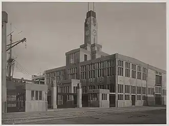 Niet meer bestaand gebouw van Koninklijke Hollandsche Lloyd aan de Oostelijke Handelskade / Veemkade, met twee van de kunstwerken op hekpijlers bij de toegang tot het haventerrein