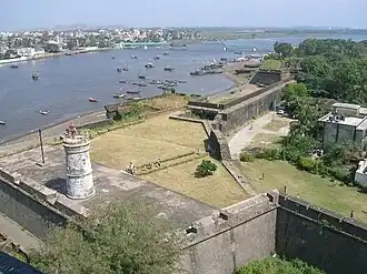 De haven en de rivier de Daman Ganga met het Moti Daman fort met de oude vuurtoren