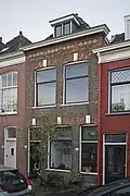 Woonhuis, in oorsprong een pand met een beneden- en bovenwoning, in 1890 gebouwd in een traditionalistisch-eclectische bouwtrant.