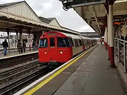 De metro uit de stad rijdt Harrow & Wealdstone binnen.