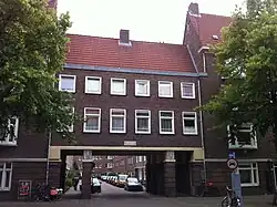 Poorten breken de lange gevelwanden, hier de toegang tot de Achillesstraat