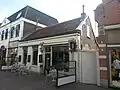 Woonhuis-winkel. Winkel uit 1822 met winkelpui uit 1907 met boekhandelsymbolen. Nu lunchroom.