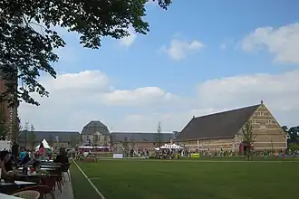 Links de verbouwde paardenstallen, midden de abdijhoeve en rechts de tiendschuur met in de oostgevel het wapen de Lamboy