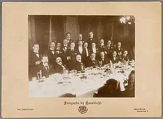 Visser (staande in het midden met snor en rok) op zijn promotiediner (1896)